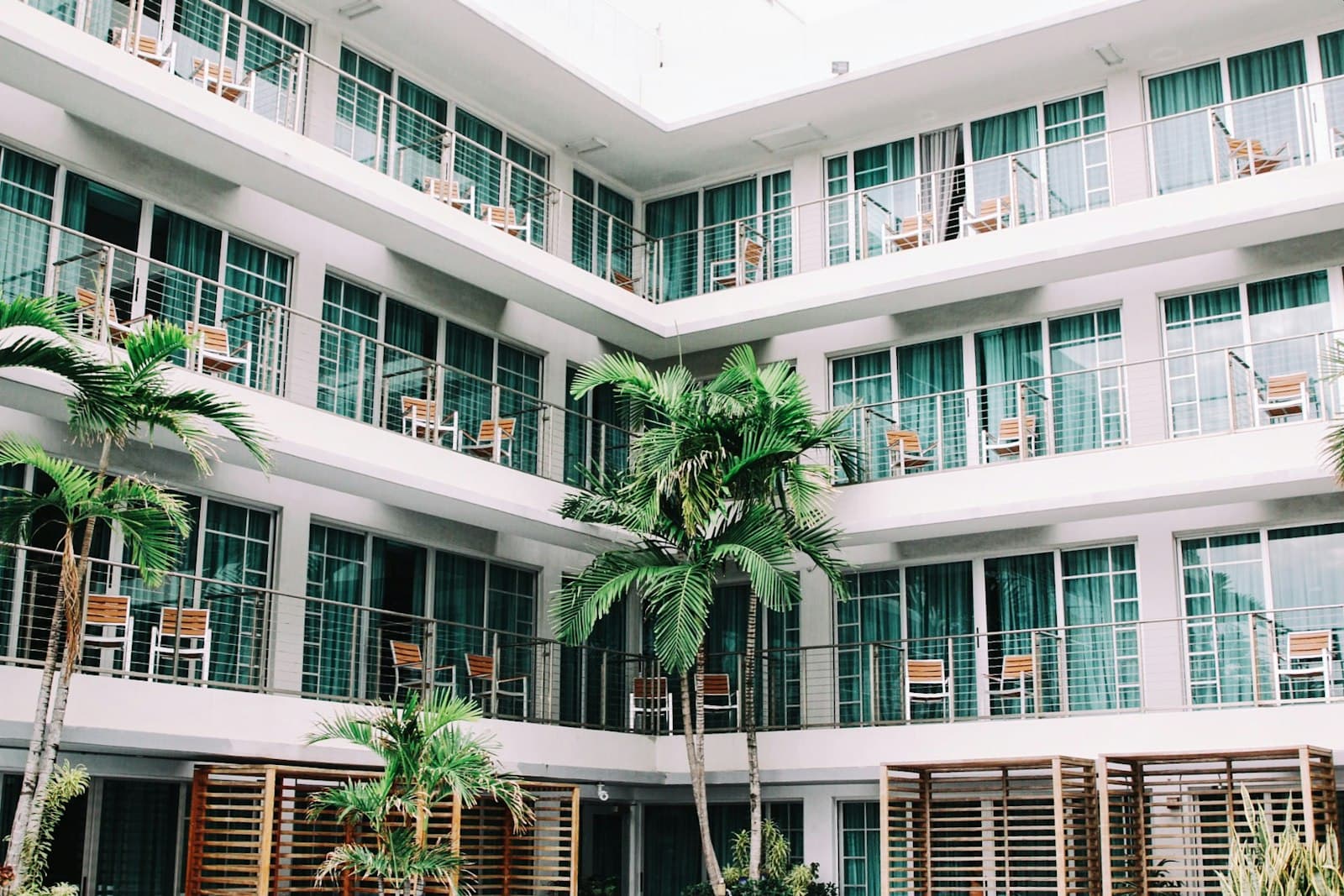 Hotel building with balconies around a palm courtyard
